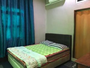 a small bed in a room with a window at Wan Guest House in Pasir Mas