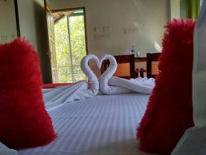 two swans shaped like hearts sitting on a bed at Blue Birds Homestay in Cherai Beach