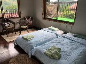 2 camas individuais num quarto com varanda em Guesthouse Yui em Hongu