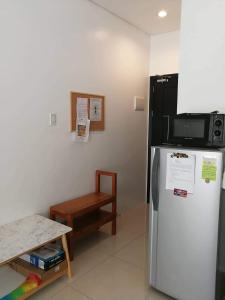 a kitchen with a refrigerator and a microwave at M's Places ORES in Bacolod
