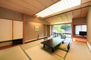 uma sala de estar com uma mesa e uma grande janela em Shikitei Morioka TsunagiOnsen em Morioka