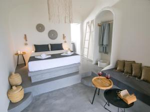 a bedroom with a bed and a living room at Santorini Villas in Vourvoulos