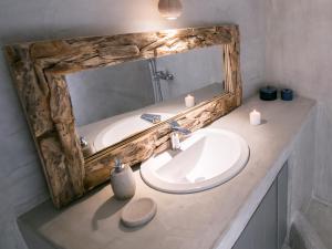 bagno con lavandino e specchio con candele di Santorini Villas a Vourvoúlos