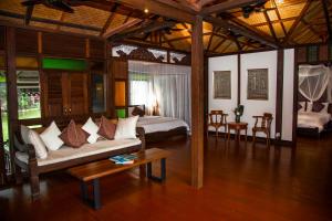 a living room with a couch and a table at Sunset Valley Holiday Houses in Kampung Padang Masirat +75 photos