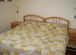 een bed met een quilt erop in een slaapkamer bij Haus mit Pool und Meerblick Altea in Altea