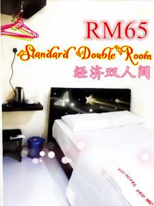 a bedroom with a white bed and a table at Red Motel in Nibung Tebal