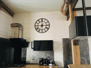 a kitchen with a clock on the wall at La Rénovée d’Antan in Avallon +7 photos
