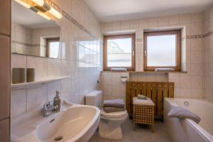 a bathroom with a sink and a tub and a toilet at Bauernhof Nagelschmiedhof in Langkampfen