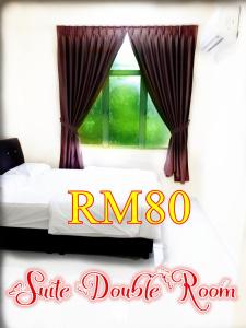 a bedroom with a bed and a window with curtains at Red Motel in Nibung Tebal