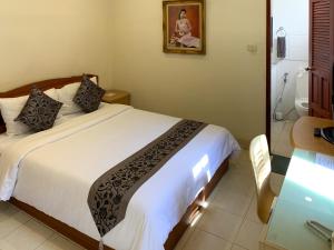 a bedroom with a bed and a bathroom with a desk at The Classroom Hotel in Pattaya