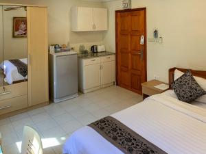 a bedroom with a bed and a kitchen with a refrigerator at The Classroom Hotel in Pattaya