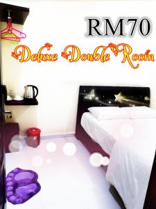 a bedroom with a bed and a purple blanket at Red Motel in Nibung Tebal