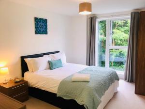 a bedroom with a bed and a window at Woking Town Centre - Parking Included by Deilamy Homes in Woking +80 photos