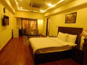 a bedroom with a bed and a living room at Diplomat Hotel in Islamabad