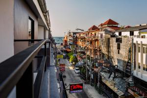 uma vista para a rua a partir de uma varanda de um edifício em The Classroom Hotel em Pattaya Central