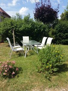 4 sillas y una mesa en un patio en Le Grenier, en Bief-des-Maisons