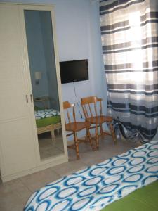 1 dormitorio con cama, sillas y espejo en B&B Mare Di S. Lucia, en Siracusa