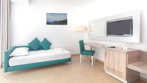 a hotel room with a bed and a desk and a tv at Hotel Nour Congress & Resort in Bizerte