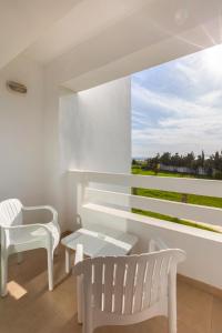 a white room with two white chairs and a window at Hotel Nour Congress & Resort in Bizerte
