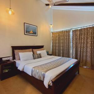 1 dormitorio con 1 cama grande y ventilador de techo en Silverador Resort, en Thane