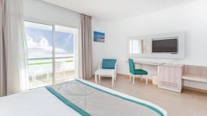 a hotel room with a bed and a desk and a television at Hotel Nour Congress & Resort in Bizerte