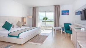 a hotel room with a bed and a table and chairs at Hotel Nour Congress & Resort in Bizerte