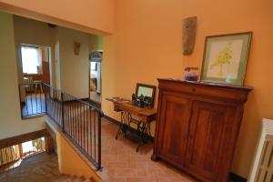 um corredor com uma escada com um armário de madeira e uma secretária em Il Casale Dorato em Filottrano