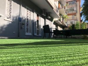 un césped frente a un edificio con un banco en Le Stanze Dell'Emiro en Palermo