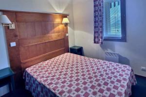 a bedroom with a bed with a red and white blanket at Résidence le Rami Les coches in Les Coches