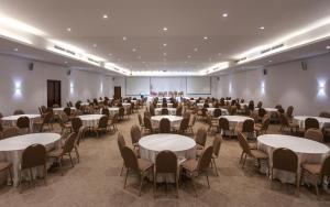 a banquet hall with tables and chairs and a projection screen at Hotel Nour Congress & Resort in Bizerte