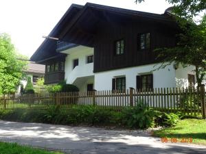 a white and black house with a wooden fence at Huge and Calm Apartment in Central Garmisch in Garmisch-Partenkirchen