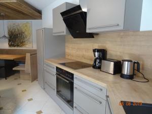 cocina con armarios blancos y fogones en Huge and Calm Apartment in Central Garmisch, en Garmisch-Partenkirchen