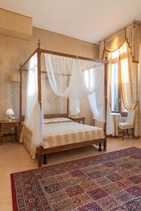 a bedroom with a canopy bed with curtains and a rug at Dimora Al Doge Beato vista canale in Venice
