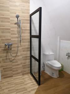 a bathroom with a shower with a toilet and a mirror at Lanta Sea House in Ko Lanta