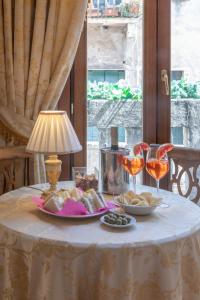 - une table avec une assiette de nourriture et des verres à vin dans l'établissement Dimora Al Doge Beato vista canale, à Venise