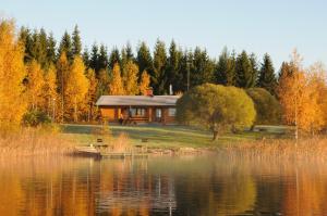 uma cabana na margem de um lago com árvores em Suvaksen Helmi em Kosula