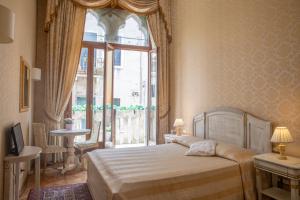 a bedroom with a bed and a large window at Dimora Al Doge Beato vista canale in Venice
