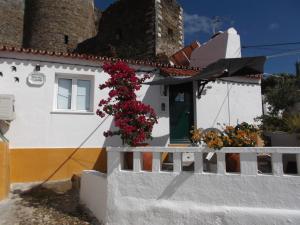 a white house with flowers on the side of it at Encosta do Castelo in Portel