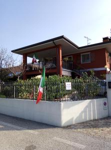 a flag on a fence in front of a house at Cjase Paola in Cassacco