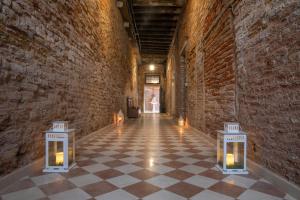 a hallway in an old building with candles on the floor at Dimora Al Doge Beato vista canale in Venice