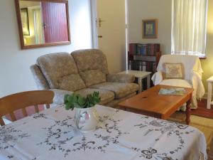 a living room with a couch and a table at Wiltshire Cottage in Port Alfred