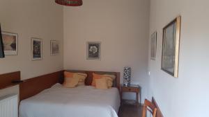 una camera da letto con un letto con lenzuola bianche e cuscini arancioni di Willa Cecylia a Międzyzdroje