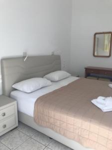 a bedroom with a large bed with two pillows and a mirror at Romantika in Platis Gialos