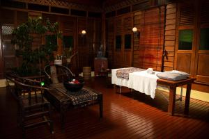 a room with a bed and a table and a chair at Sunset Valley Holiday Houses in Kampung Padang Masirat