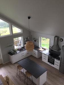 a kitchen with white cabinets and a black counter top at Kungsbacken i Tived in Tived