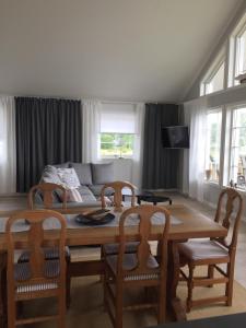een woonkamer met een tafel en stoelen en een bank bij Kungsbacken i Tived in Tived