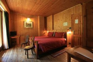Schlafzimmer mit einem Bett, einem Schreibtisch und einem TV in der Unterkunft Albergo Villa Anna Maria in Champoluc