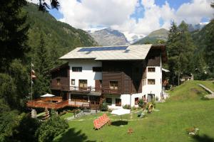 une maison avec des panneaux solaires au sommet d'une colline dans l'établissement Albergo Villa Anna Maria, à Champoluc