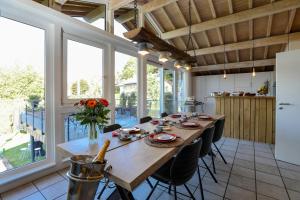a large dining room with a table and some windows at Le Sorbier - Gîte et chambres d'hôtes in Malmedy