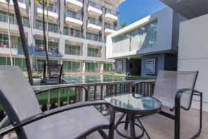 a balcony with chairs and a table and a building at Sugar Marina Hotel - FASHION - Kata Beach - SHA Extra Plus in Kata Beach